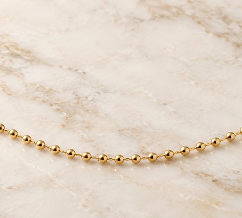Ketting met bolletjes, speelse geometrische vormgeving met bolletjes